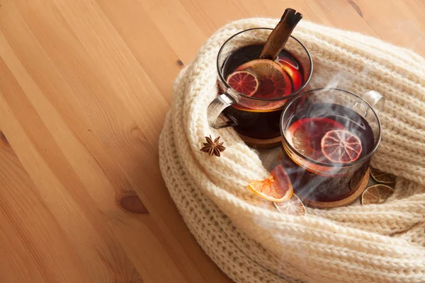 Seasonal and holidays concept . Christmas mulled wine with beutiful orange slices inside the glass and some smoke, covered with warm white scarf . Very warm and cozy atmosphere . — Stock Photo, Image