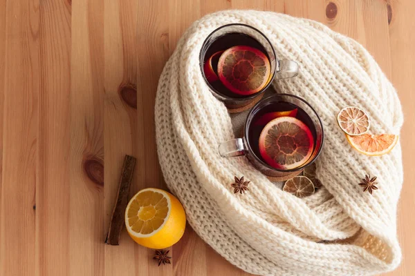 Seasonal and holidays concept . Christmas mulled wine with beutiful orange slices inside the glass , covered with warm white scarf . Very warm and cozy atmosphere . Top view — Stock Photo, Image