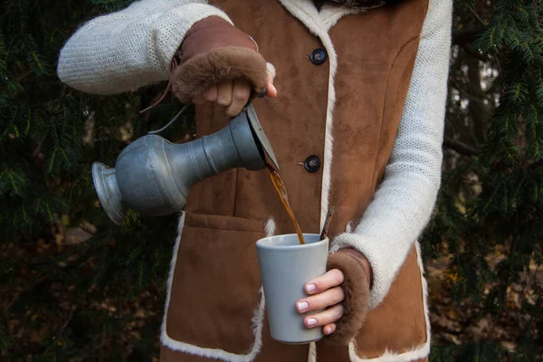 숲에서 캠핑 생활양식입니다. 여자 모피 글러브에서 세라믹 컵에 뜨거운 커피를 부 어 . — 스톡 사진