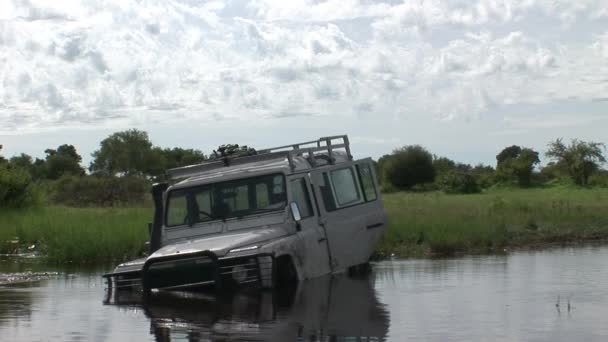 Carro dirigindo terra fileld molhado safari Arfica — Vídeo de Stock