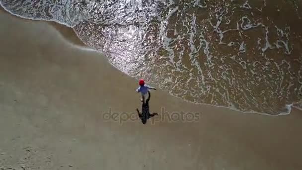 Menino brincando com o mar aéreo drone vista superior 4K UHD vídeo — Vídeo de Stock