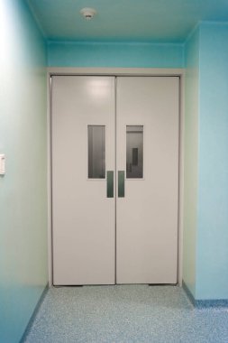 Hastanenin kapısı beyaz bir koridorda..