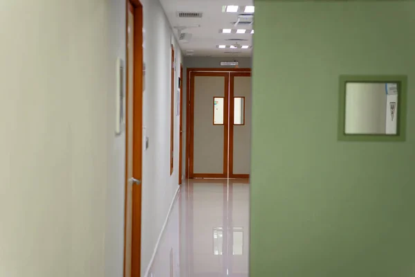 The door to the hospital in a white hallway.