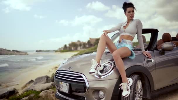 在加勒比海沿岸一个漂亮的时髦女人站在一辆没有屋顶的汽车旁边 — 图库视频影像