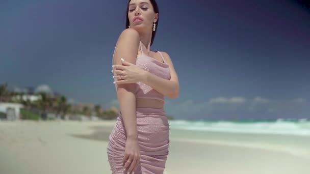 在海滨的相机前 穿着粉色连衣裙的漂亮时髦女人摆着姿势 — 图库视频影像