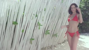 Kameranın önünde poz veren, kırmızı mayolu güzel, modaya uygun bir kız..