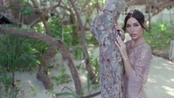 美しいブルネットはジャングルの中の家の近くのカメラの前でポーズ — ストック動画