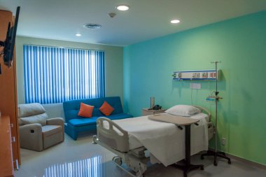 Clean empty hospital room ready for one patient. Moderate lighting. clipart