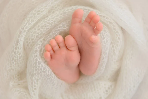 Schöne kleine Füße eines Neugeborenen in Tuch gewickelt. — Stockfoto