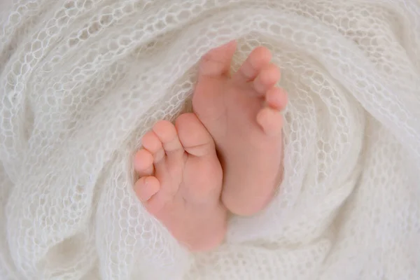 Schöne kleine Füße eines Neugeborenen in Tuch gewickelt. — Stockfoto