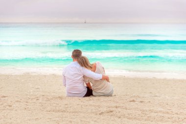 Bir adam ve bir kadın deniz kıyısında oturuyorlar..