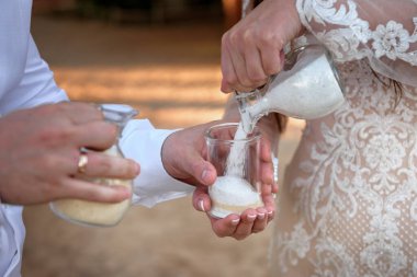 Gelin ve damat kum törenini gerçekleştiriyorlar. Meksika.