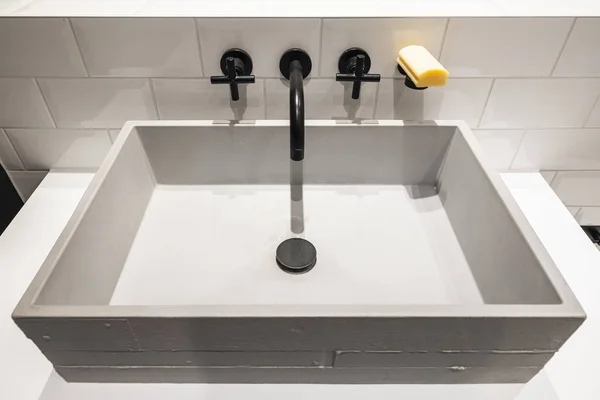 Lavabo en béton avec robinet noir — Photo