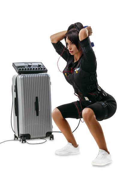 Beautiful EMS fitness woman doing dumbbell squats