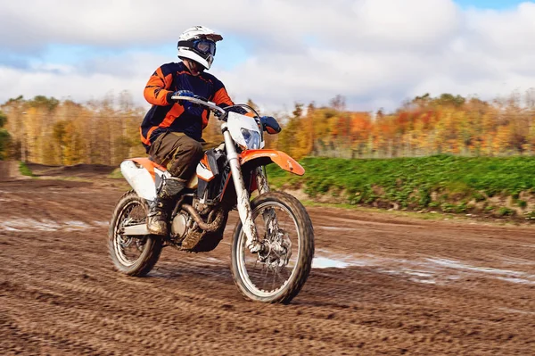 摩托车越野赛，耐力赛骑手在土路上。在他身后的森林 — 图库照片