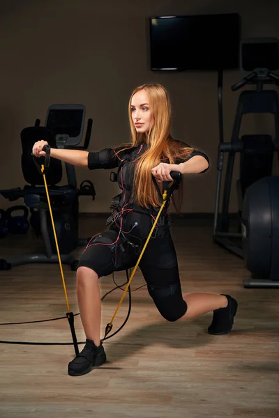 Bionda EMS fitness girl fare esercizio per le mani e la schiena con expa — Foto Stock