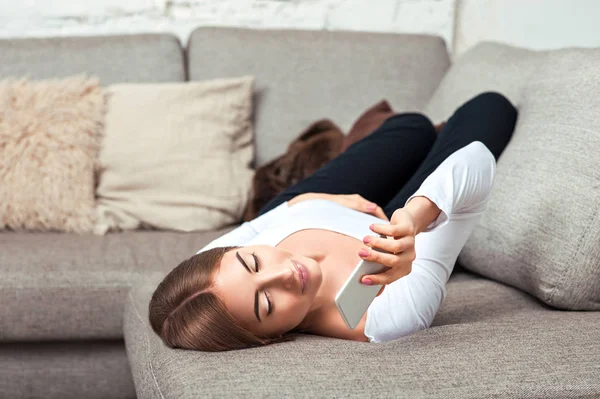 Woman talking on cell phone lying on couch