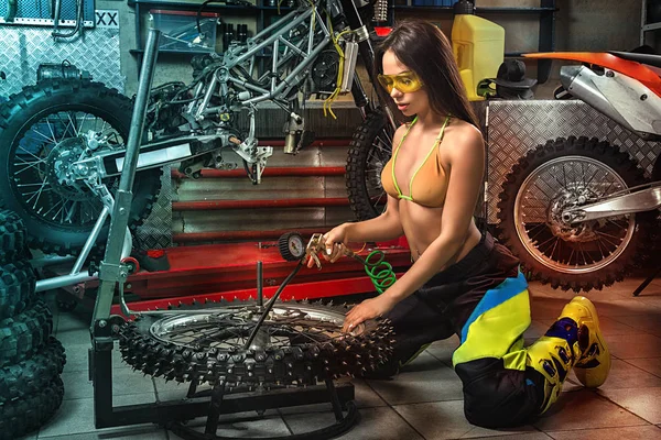 Sexy dívka v garáži čerpací pneumatiky — Stock fotografie