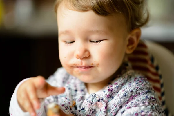 Essen fröhliche Baby-Mädchen mit chaotischem Gesicht — Stockfoto