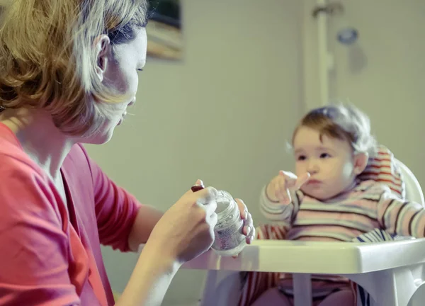 Mutter füttert ihr kleines Mädchen mit einem Löffel — Stockfoto