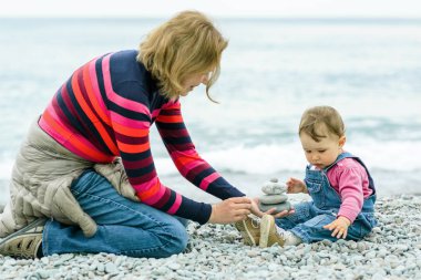 Anne ve bebeği kumsalda oynarken
