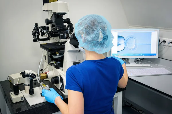 Kadın araştırmacı laboratuarda mikroskop kullanarak