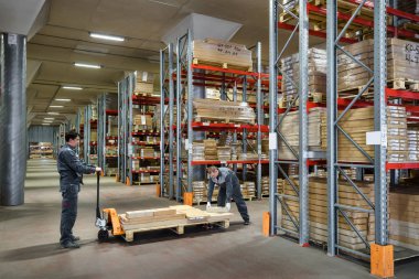 Bir ambarda çalışan işçilerin forklift ile