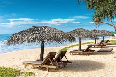 Tropik sahilde şemsiyelerle Beach yataklar