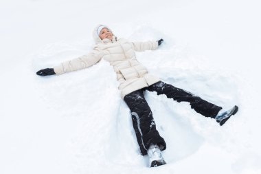 Portre sevimli genç bir kadın bir kar üzerinde yalan