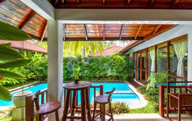 Palmiye ağaçları arasında lüks villa manzarası. Gar 'la yüzme havuzu
