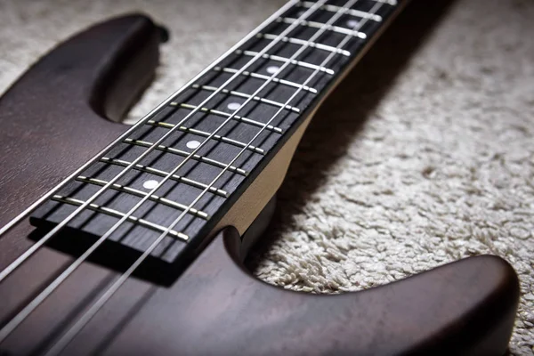 Bass guitar with four strings closeup. Detail of popular rock mu
