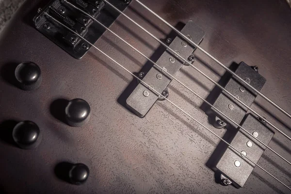 Bass electric guitar with four strings closeup. Detail of popula