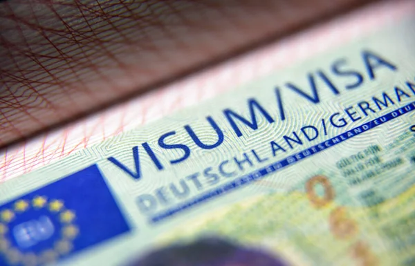 Visa stamp in passport close-up. German visitor visa at border c