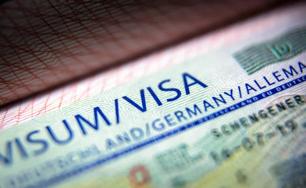 Visa stamp in passport close-up. German visitor visa at border c