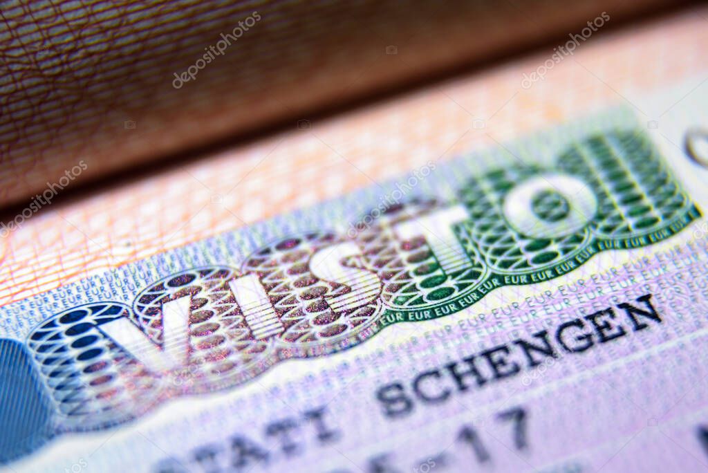 Visa stamp in passport close-up. Italian visitor visa at border 