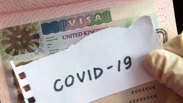 コロナウイルスの概念 パスポートにはCovid 19コロナウイルスおよび英国ビザが記載されています コロナウイルスに感染した観光客の国境管理と隔離 コロナウイルスの新規発生 中国武漢の流行 — ストック写真