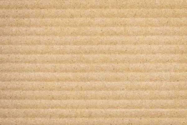 Paper cardboard background. Natural corrugated carton sheet. Kraft cardboard texture with horizontal stripes. Seamless light brown paperboard for background or backdrop.