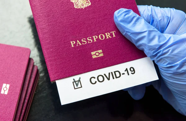 COVID-19 coronavirus pandemic and travel concept, COVID-19 note in passport. Novel corona virus outbreak, spread of epidemic from China. Quarantine of tourists infected with SARS-CoV-2.