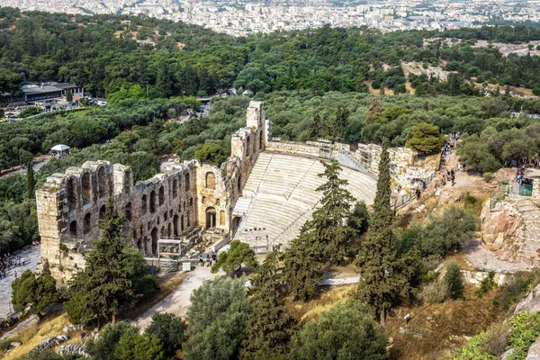 Athens city view from above, ruins of Odeon of Herodes Atticus at Acropolis, Greece. Ancient theater is famous landmark of Athens, monument of classic Greek culture. Urban landscape of Athens center.