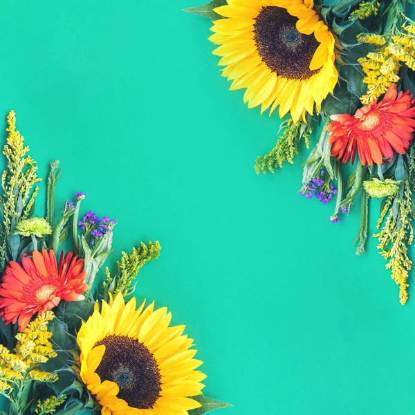 Diferentes flores de verano de colores tumbados sobre fondo de menta — Foto de Stock