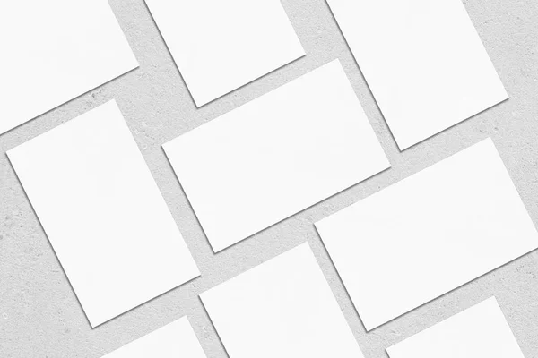 Tom vit rektangel visitkort mockups liggande diagonalt på neutral grå betong bakgrund — Stockfoto