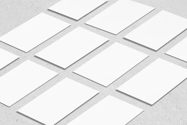 Tom vit rektangel visitkort mockups liggande diagonalt på neutral grå betong bakgrund — Stockfoto