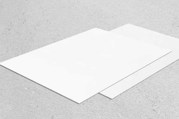 Két üres fehér téglalap poszter mockup fekvő átlósan semleges szürke beton háttér — Stock Fotó