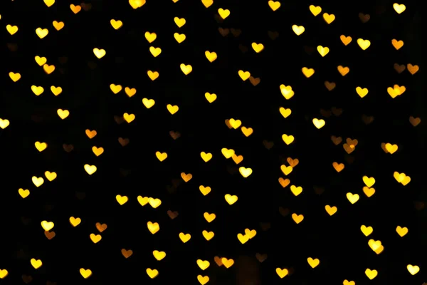 Gouden gekleurde hart bokeh feestelijke glitter achtergrond — Stockfoto