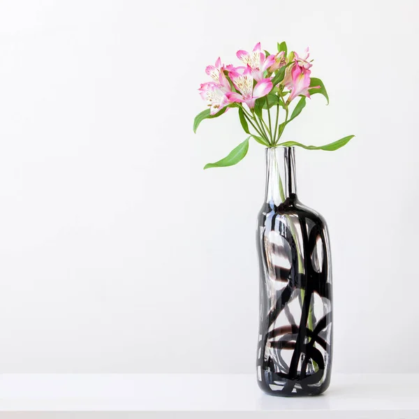 Pink alstroemeria in glass vase on white table — Stock Photo, Image