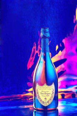 Krasnodar, Russian Federation - February 19, 2020: Bottle of Champagne Dom Perignon Vintage 2008 produced by the French vinery brand Moet and Chandon on neon holographic colorful disco background.