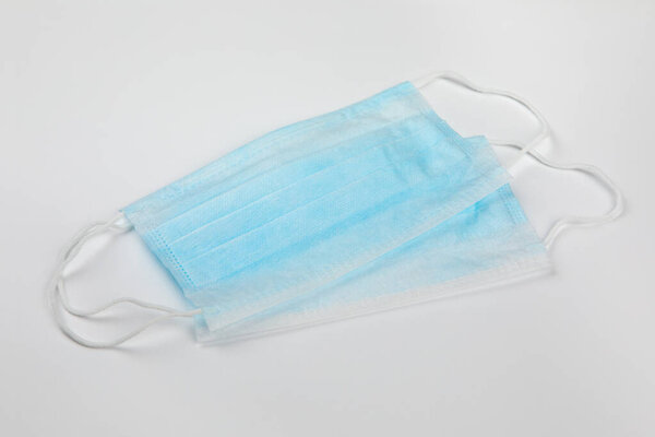 Предотвращение коронавируса. Две типичные 3-слойные синие хирургические медицинские маски, лежащие по диагонали друг на друге на белом фоне. Концепция защиты от вирусов короны гигиены
.