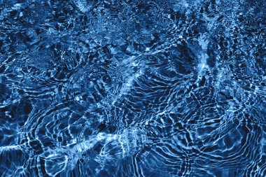 Koyu mavi renkli kabarcıklar ve sıçramalarla kabarık su yüzeyi dokusu yakın çekim. Yeni moda soyut doğa geçmişi. 2020 renk kavramı