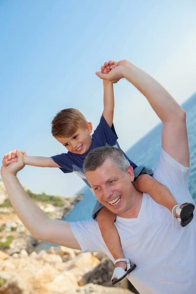 Pai e filho piggyback em férias — Fotografia de Stock
