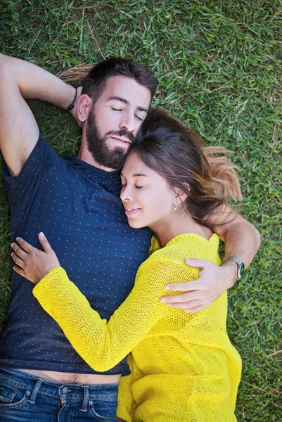 Влюбленная пара, лежащая на траве летом — стоковое фото